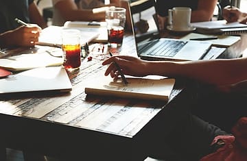Catatan rapat dan laptop di meja