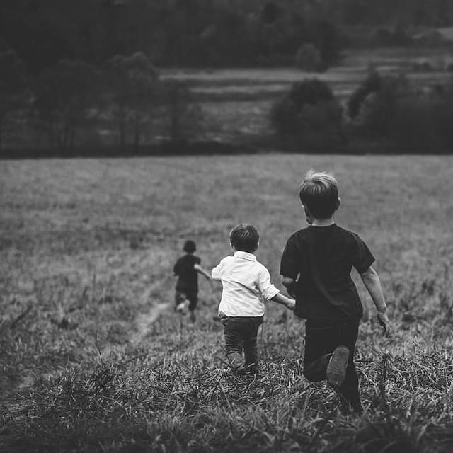 Anak-anak berlari di padang rumput