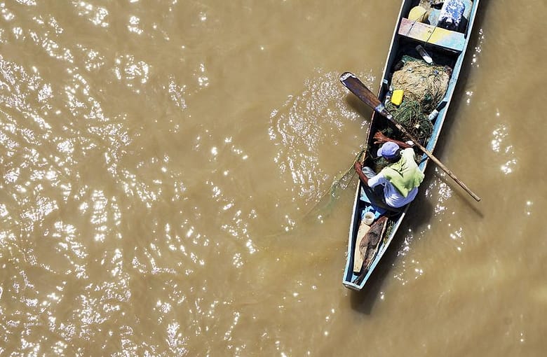 Perahu relawan menyusuri air banjir