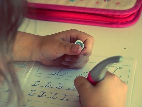 Anak belajar menulis di buku