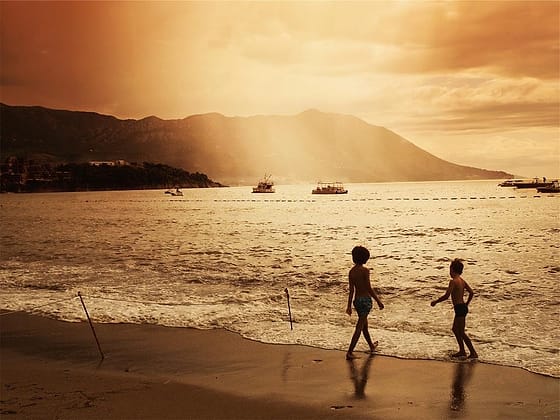 Anak-anak bermain di pantai saat senja