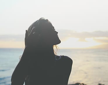 Wanita menikmati senja di pantai
