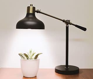 Lampu meja hitam di samping tanaman