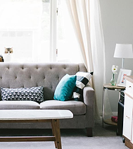 Sofa tufted abu-abu dengan bantal
