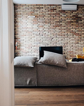 Sofa abu-abu tiga dudukan dengan bantal