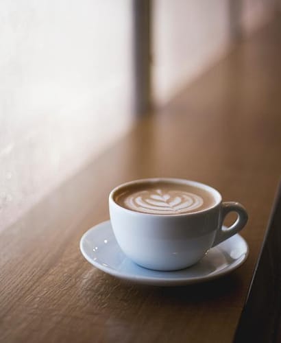 Secangkir latte di meja kayu