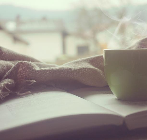 Kopi hangat dan buku di dekat jendela