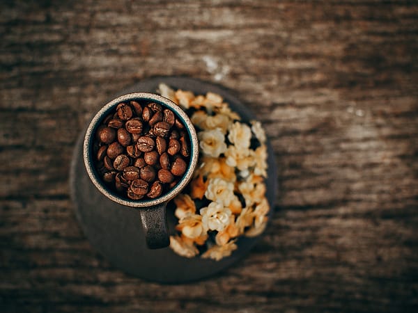 Biji kopi dan kudapan di meja kayu