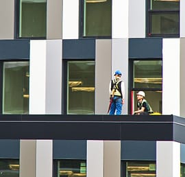 Pekerja memasang fasad gedung