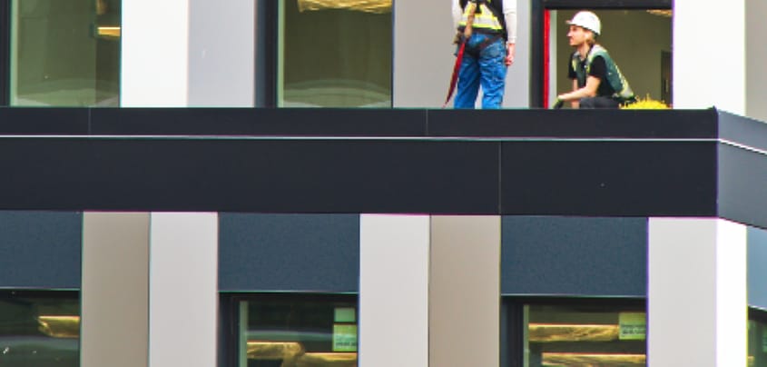 Pekerja memasang fasad gedung