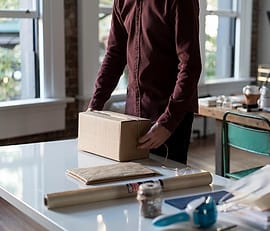 Petugas mengemas paket di meja kerja