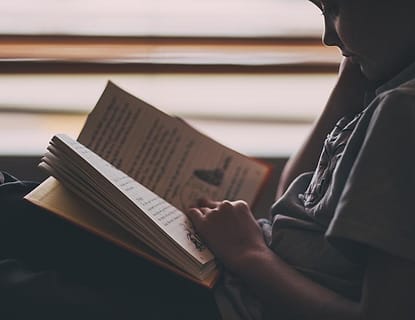 Membaca buku di dekat jendela
