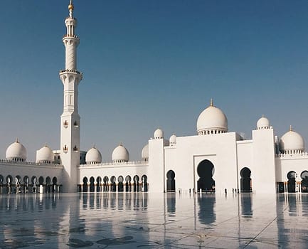 Halaman masjid dengan menara dan kubah putih