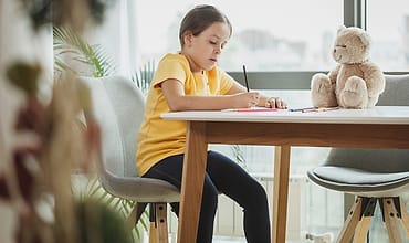 Anak belajar menulis di meja