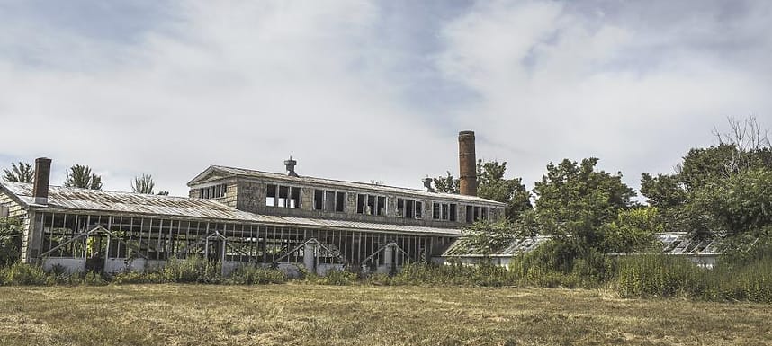 Gedung pabrik lama di tengah lahan kosong