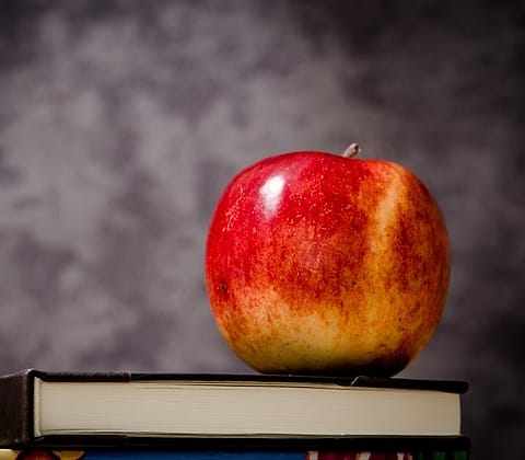 Buku dan apel di meja kelas