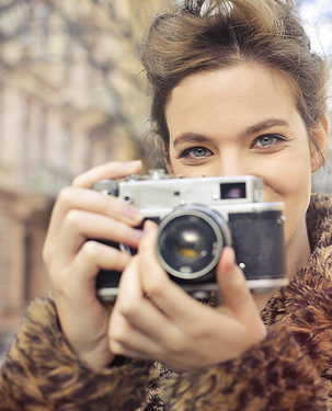 Fotografer tersenyum memegang kamera
