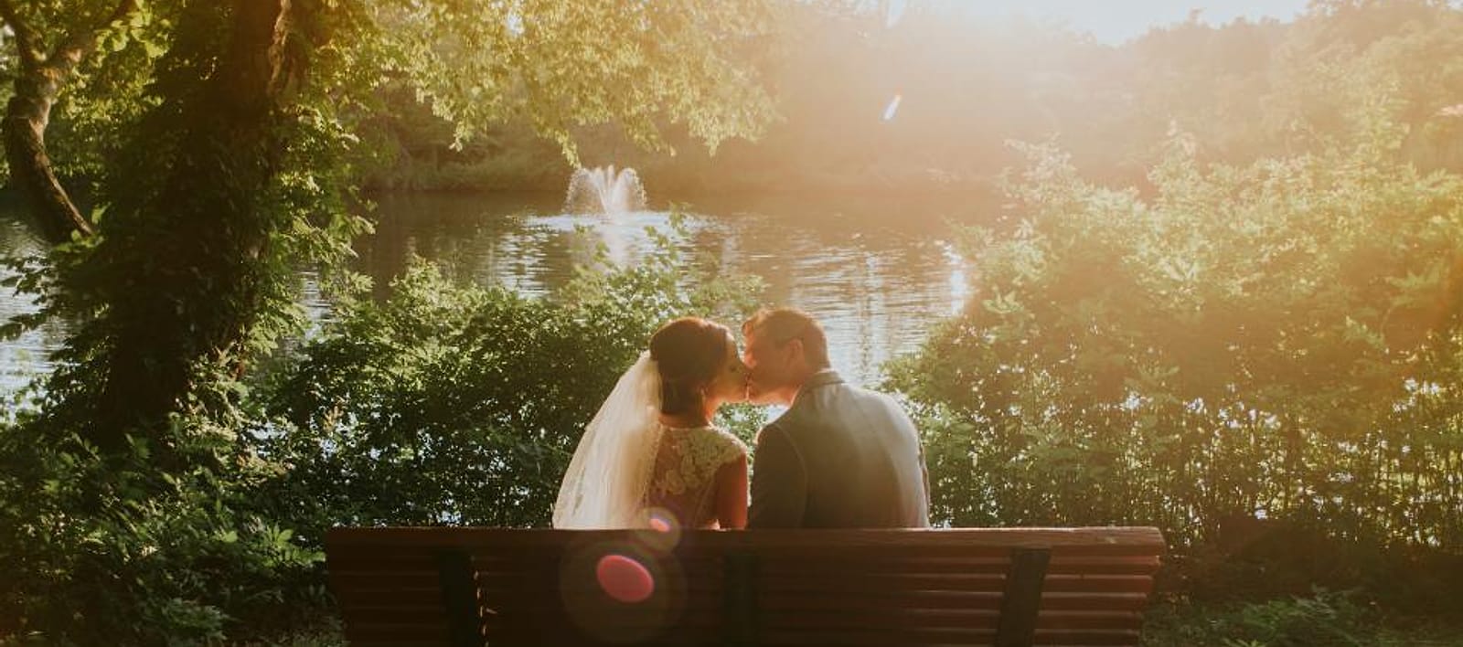 Pasangan pengantin duduk di bangku taman