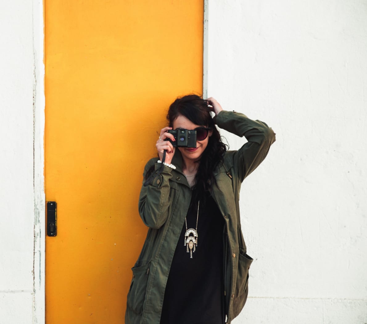 Fotografer dengan kamera di depan pintu kuning
