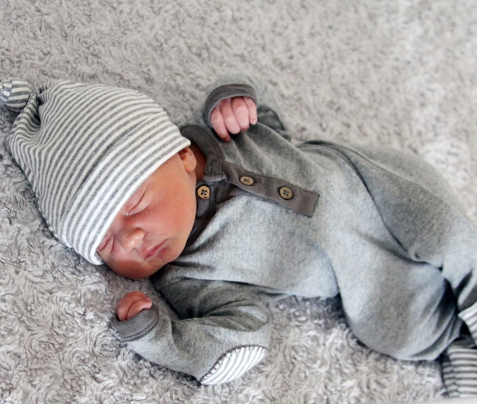 Bayi baru lahir tidur dengan topi rajut