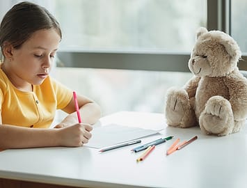 Anak menggambar dengan pensil warna
