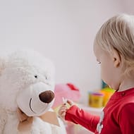 Balita bermain dengan boneka beruang
