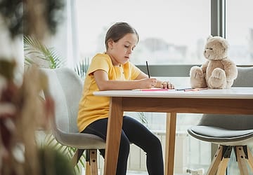 Anak menggambar di meja kelas