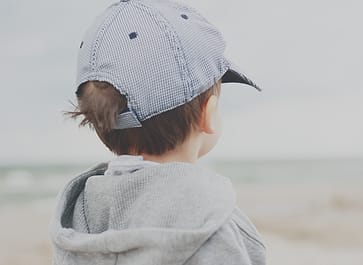 Dua anak duduk di tepi danau