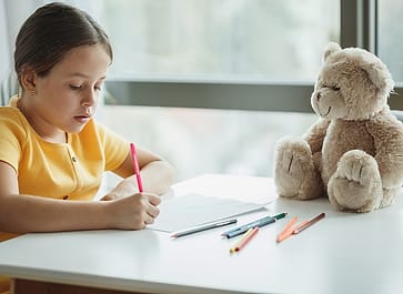 Anak menggambar dengan pensil warna