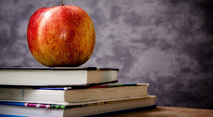 Buku dan apel di meja kelas